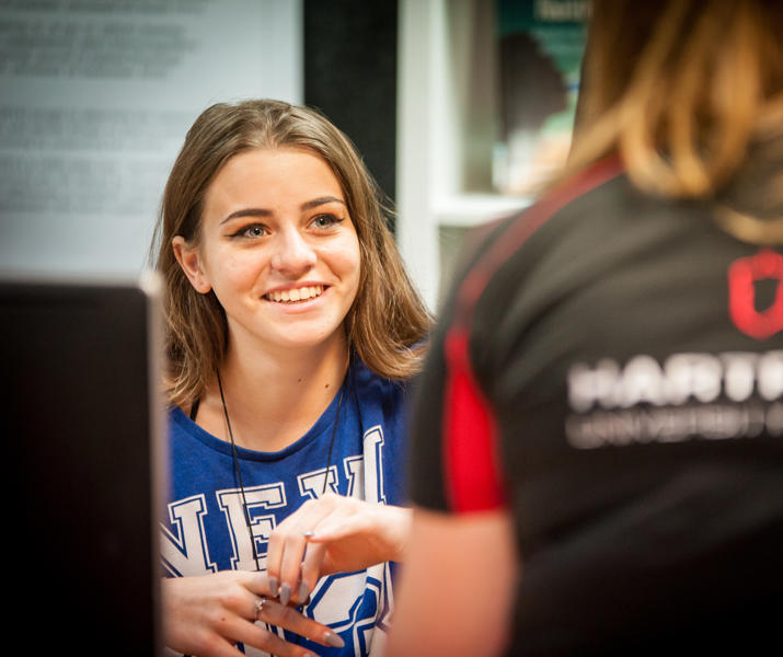 Image of a student smiling at a member of staff sat in front of them