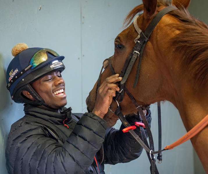Image of international student laughing with horse whilst holding the harness
