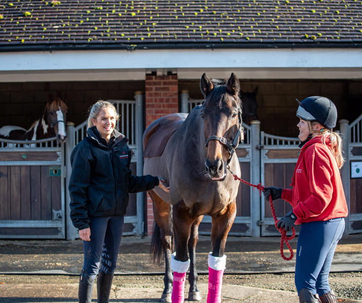 Two students with a horse in the Equine Yard