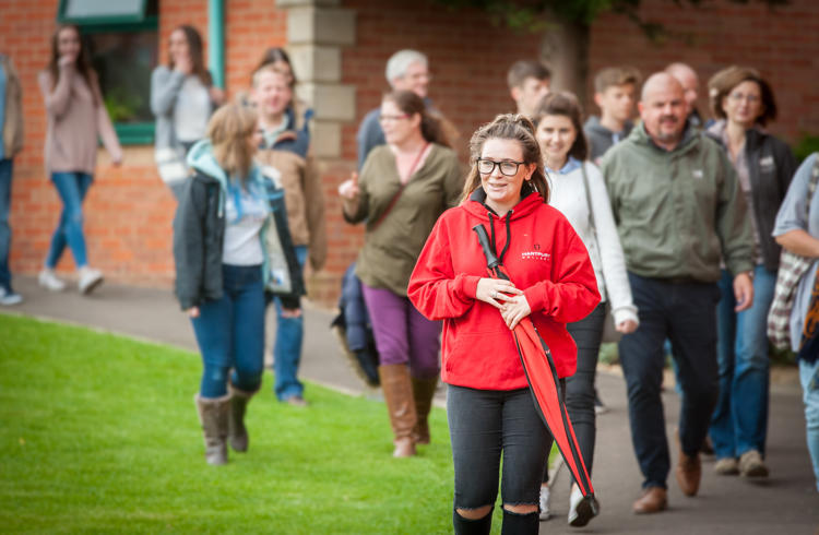 Open Day Guests On Tour With Student Ambassador Holding Umbrella