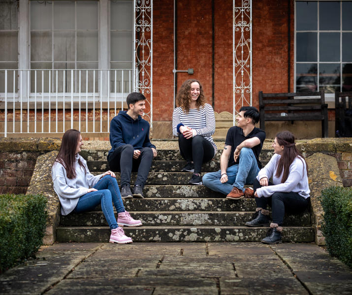 Students Sat On Steps Outside Hartpury House