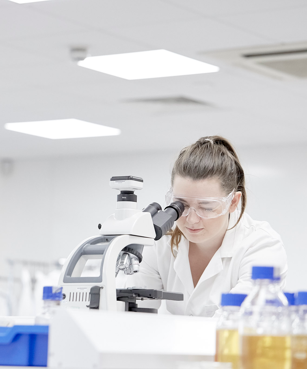 Female Student In Lab Using Microscope