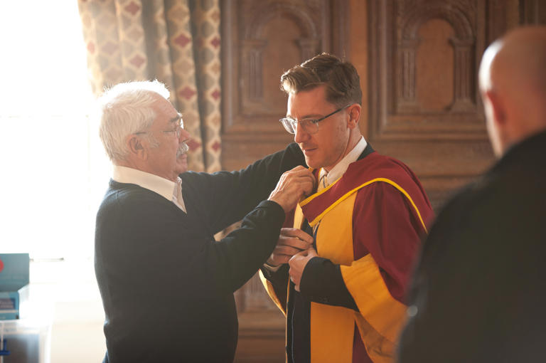 Male Getting Into Robes At Graduation