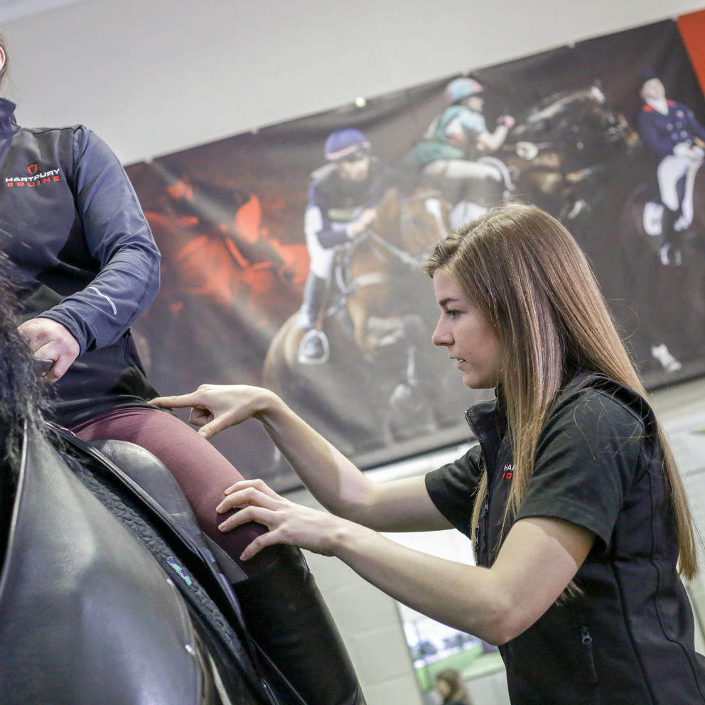 Lady Helping A Rider With Position On Simulator