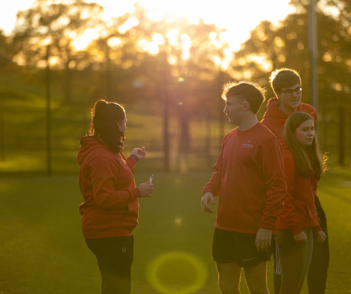 Group of sports students outside in setting sun