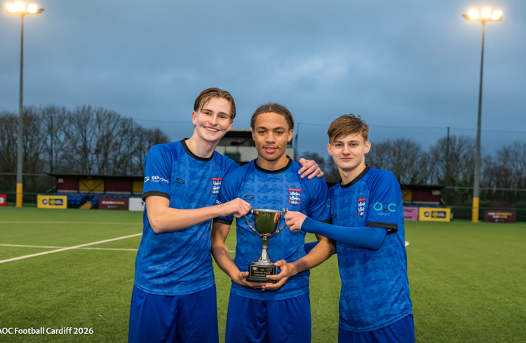 Three Footballers Holding Trophy