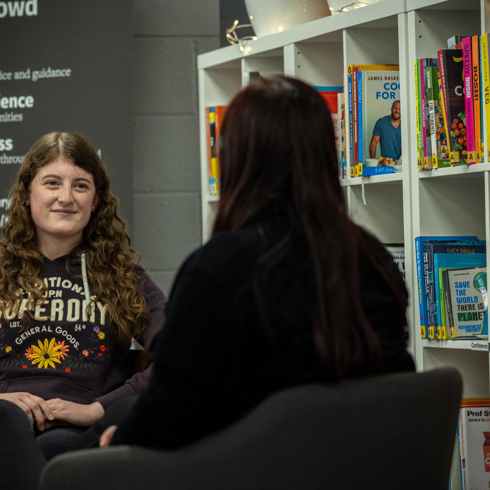 Student Support staff member sat opposite a student