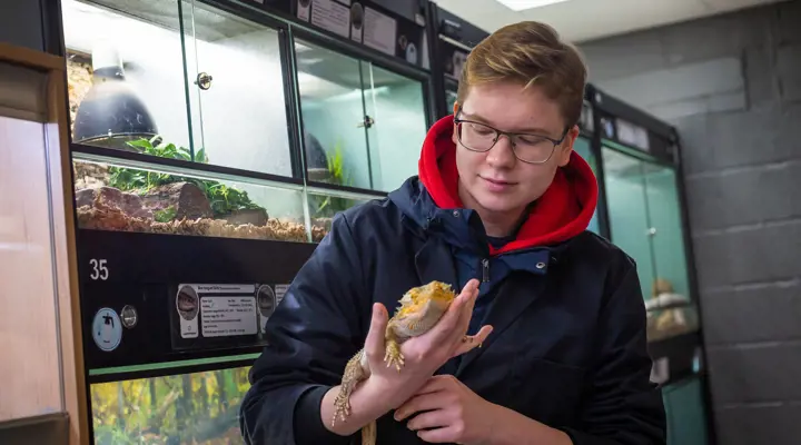 Male Student Holding Reptile